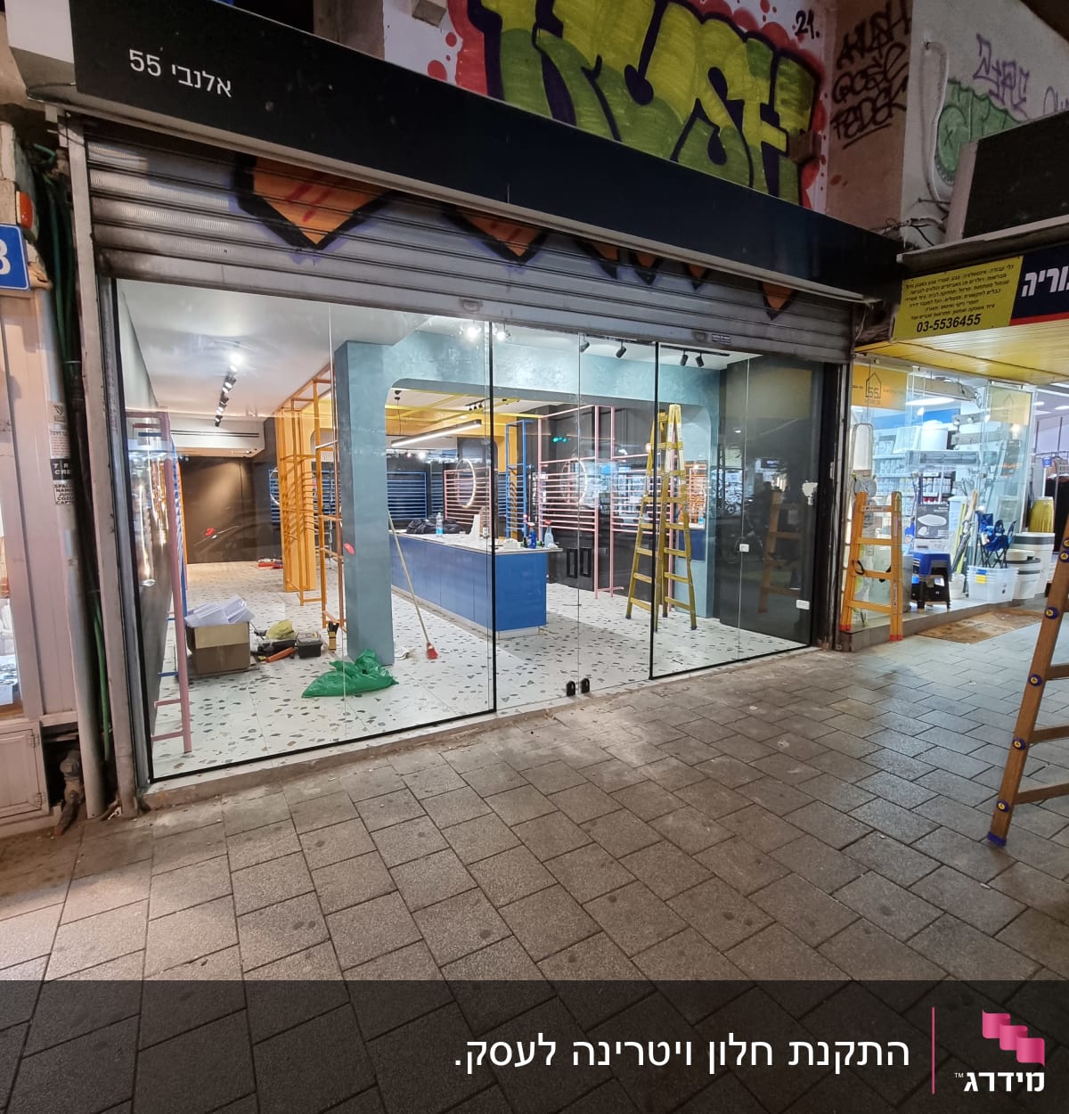 חלון זכוכית גדול בחזית חנות עם סולם בפנים